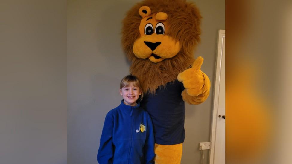 Doctor dressed as a lion standing with his daughter