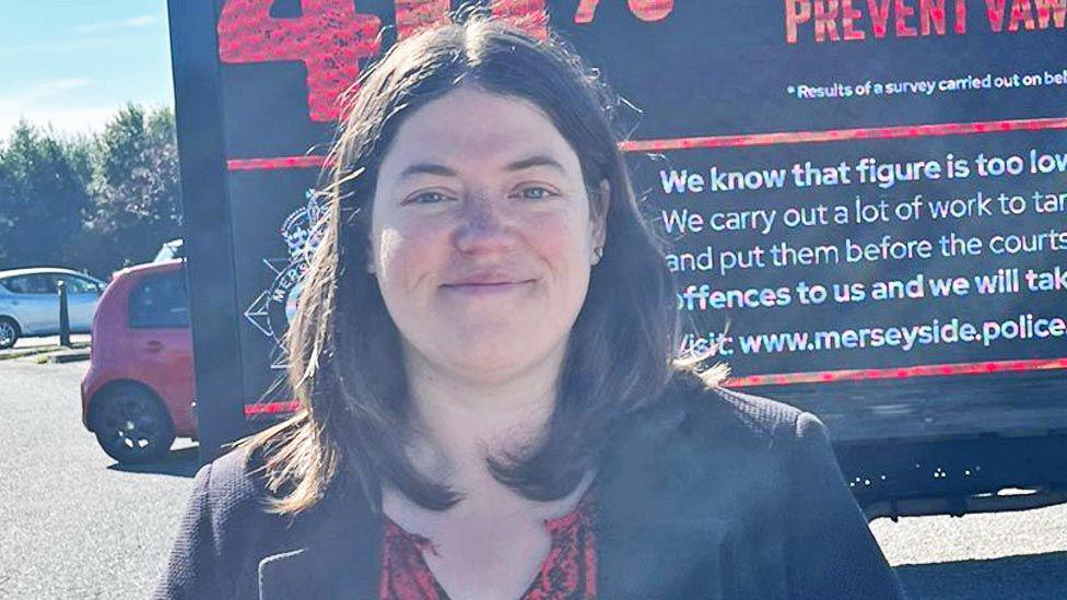 Emily Spurrell with long brown hair and black suit jacket