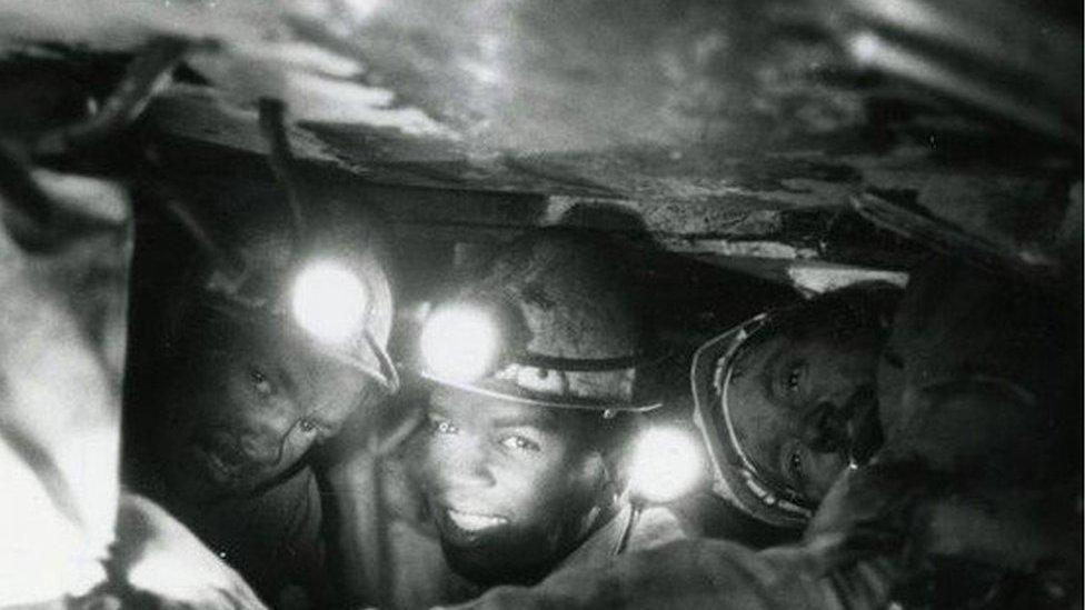 Three of the run men working under the chocks at the coal face at Gedling Colliery