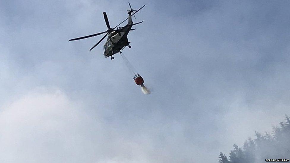 Helicopter dropping water over fire