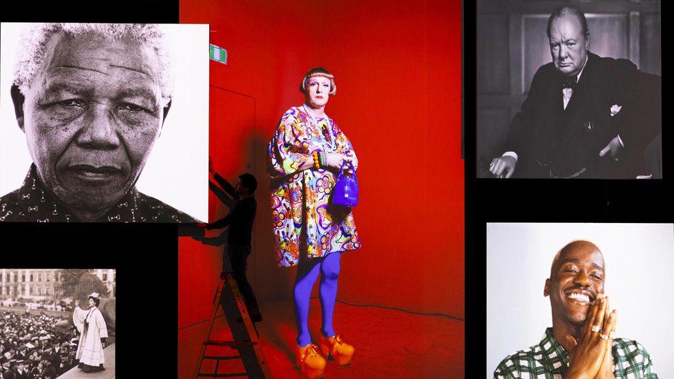 Screens showing portraits of Nelson Mandela, Grayson Perry, Winston Churchill, Emmeline Pankhurst and Ncuti Gatwa, with a silhouetted worker on a ladder in front of them