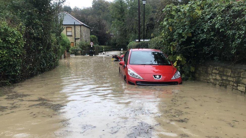 Red car half submerged in water