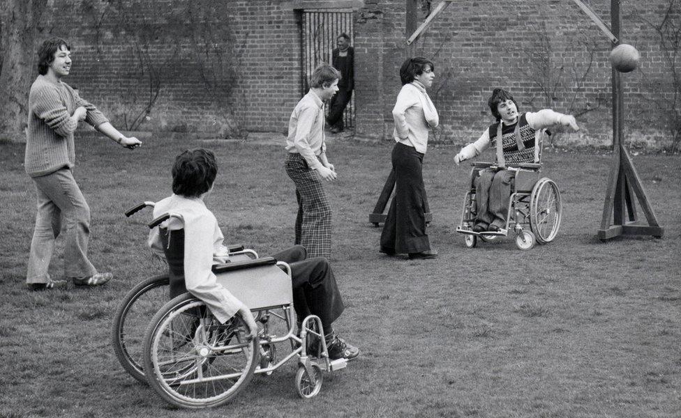 Five boys playing sports outside. Two are wheelchair users