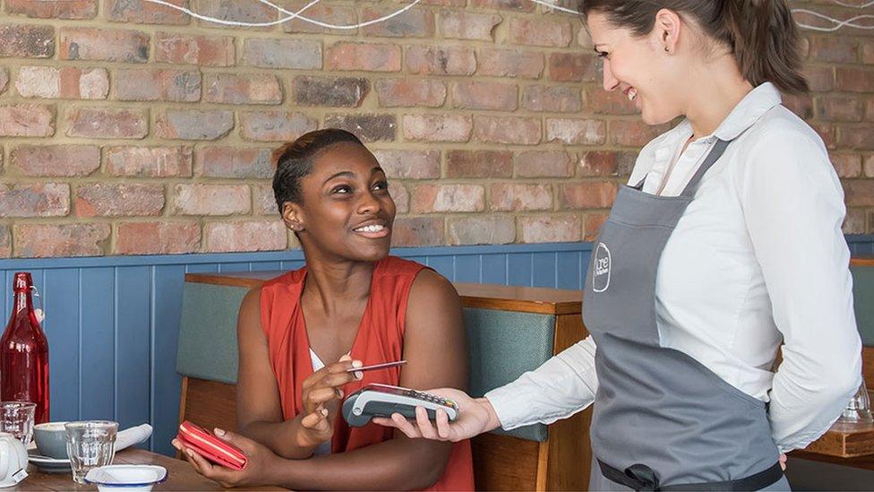 A customer using contactless to pay for a meal at a restaurant