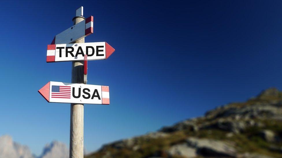 A post with 'trade' and USA' written on signs pointing in opposite directions