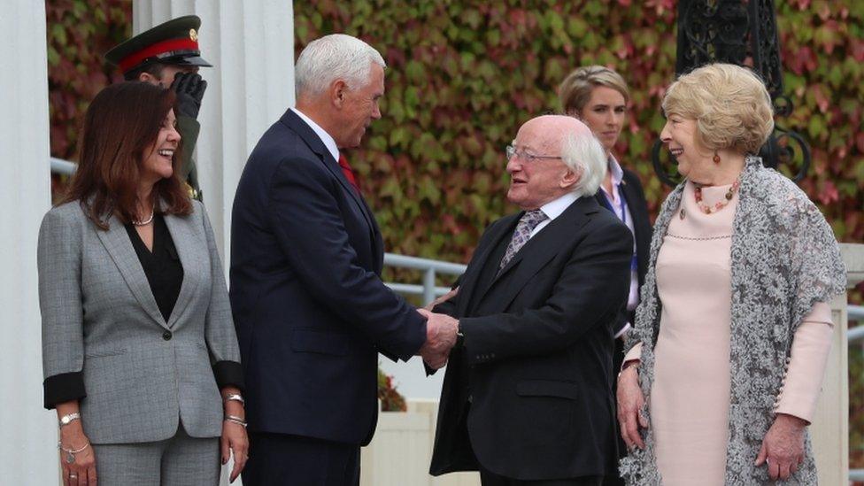 Mike Pence shakes hands with Irish President Michael D Higgins in the company of his wife Karen and Mr Higgins' wife Sabina