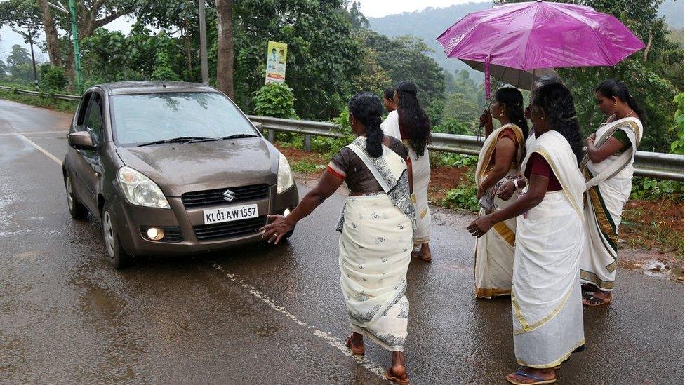 Hindu devotees stop a car to check if any women of menstruating age are headed towards the Sabarimala temple.