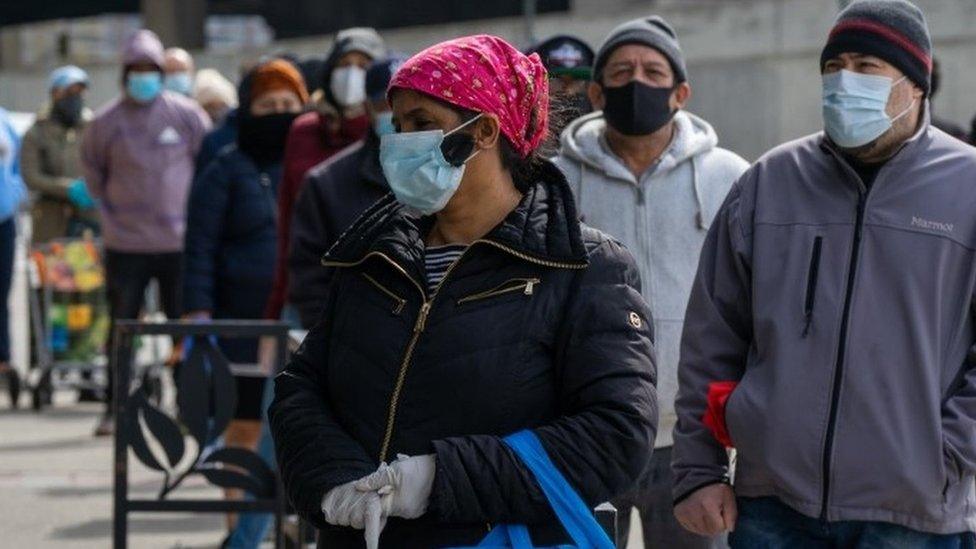 People stand in line outside of Food Fair supermarket on 163rd Street on April 14, 2020 in the Bronx borough of New York City.