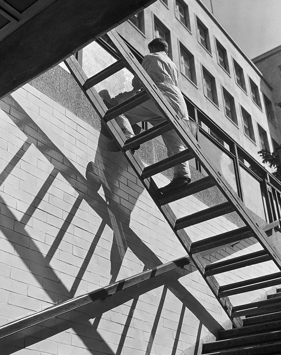 Window washer balancing on a ladder, Berlin, mid-1930s.