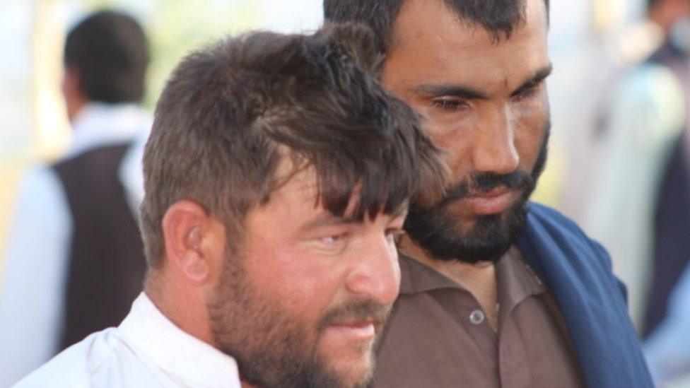 Lal Mohammad Zaer, supported by a sighted guide in Wardak district, Afghanistan on 14 June 2018