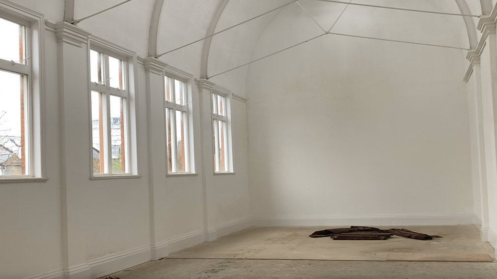 A big arched roof and white walls inside the Mill Road building