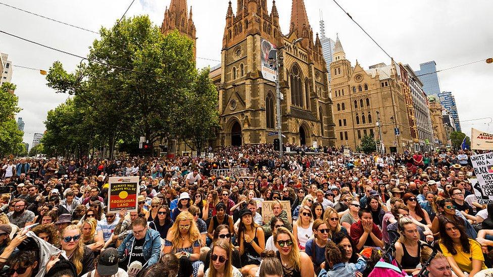 A huge, packed crowd at a junction in the centre of Melbourne city