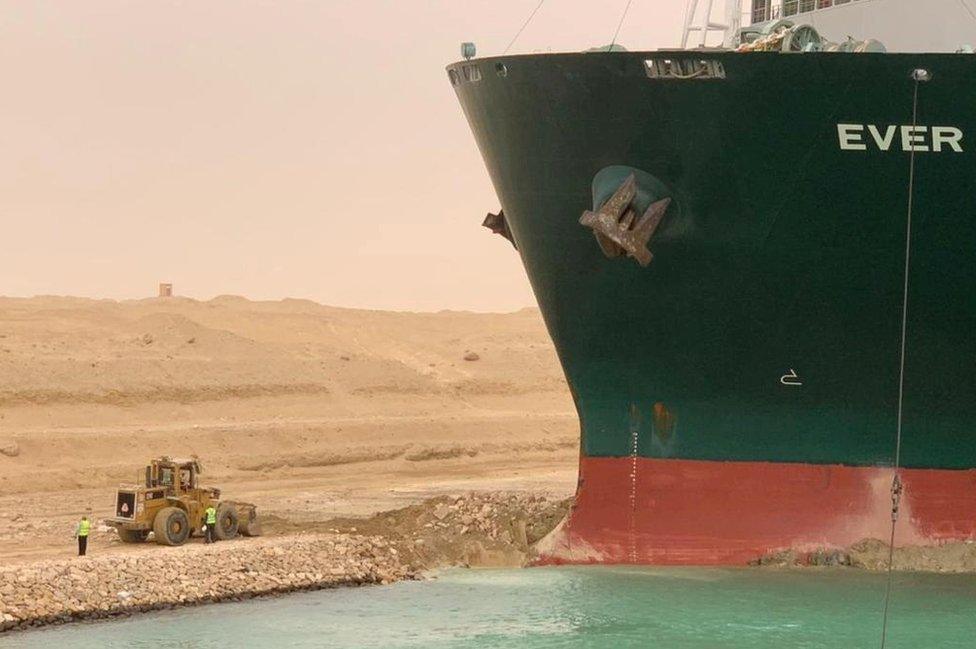 Workers try to free the MC Ever Given container ship which ran aground in Suez Canal in Egypt