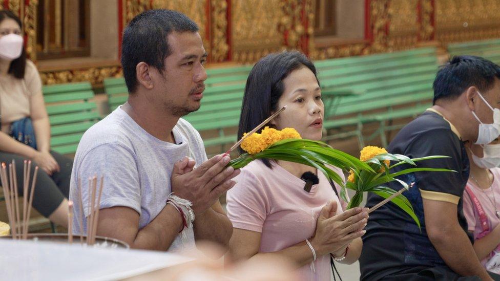 Mr Wichian, seen here with his wife, at a temple