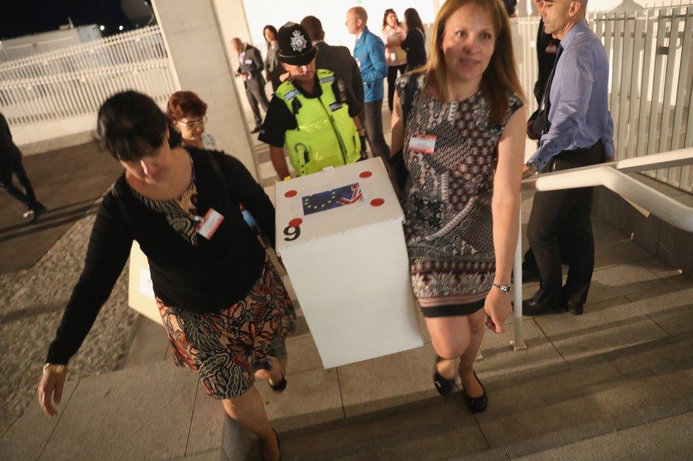 City workers carry in a ballot box for counting at Gibraltar University