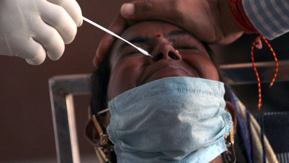 A health worker in personal protective equipment (PPE) collects a swab sample from metro commuters for Covid-19 Rapid Antigen Testing (RAT), at a kiosk setup at Shadipur Metro Station, on September 24, 2020 in New Delhi.