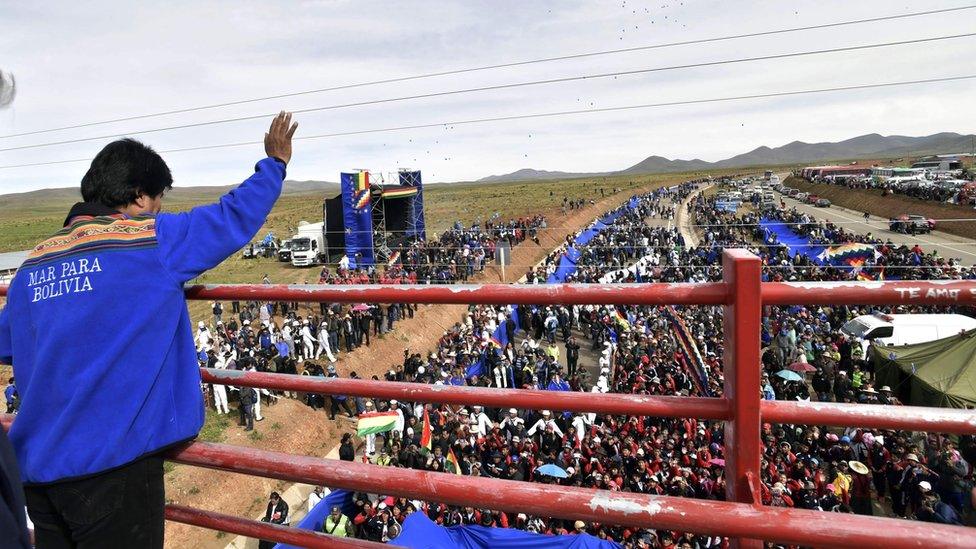 Handout picture released by the Bolivian presidency press office showing President Evo Morales waving to the crowd during the unfolding of a huge 200km flag