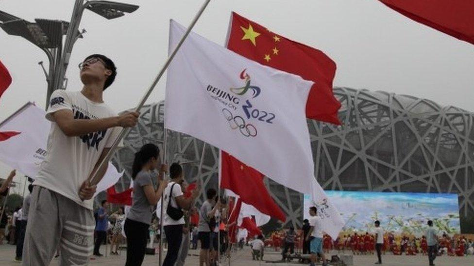 Chinese performers hold up flags of China and Beijing 2022 during a rehearsal in Beijing. Photo: 30 July 2015