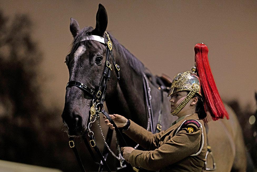 Members of the Household Cavalry Mounted Regiment prepare for a night time rehearsal for the coronation of King Charles III at Hyde Park Barracks on 17 April 2023 in London, England