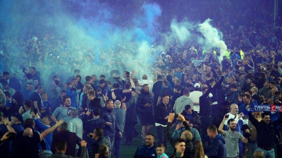 Everton fans celebrate on the pitch