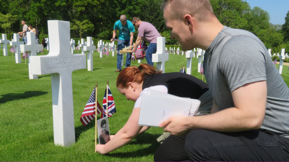 People by graves at the Cambridge American Cemetery in Cambridge, England