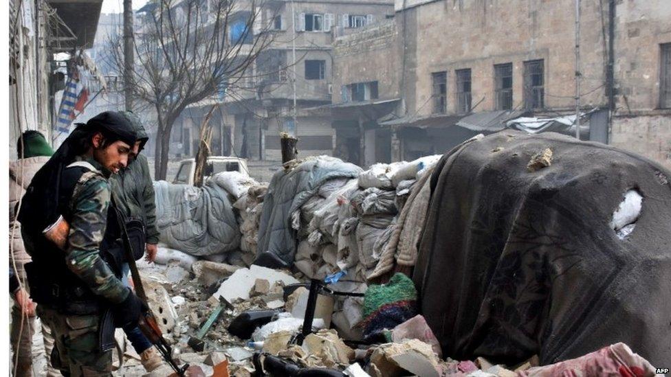 A member of the Syrian government forces walking amid the rubble of the Al-Kalasseh neighbourhood in eastern Aleppo