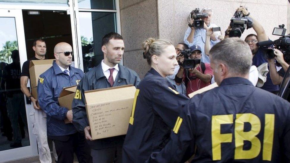 FBI agents carry boxes and computers from the headquarters of Concacaf after it was raided on 27 May in Miami Beach, Florida