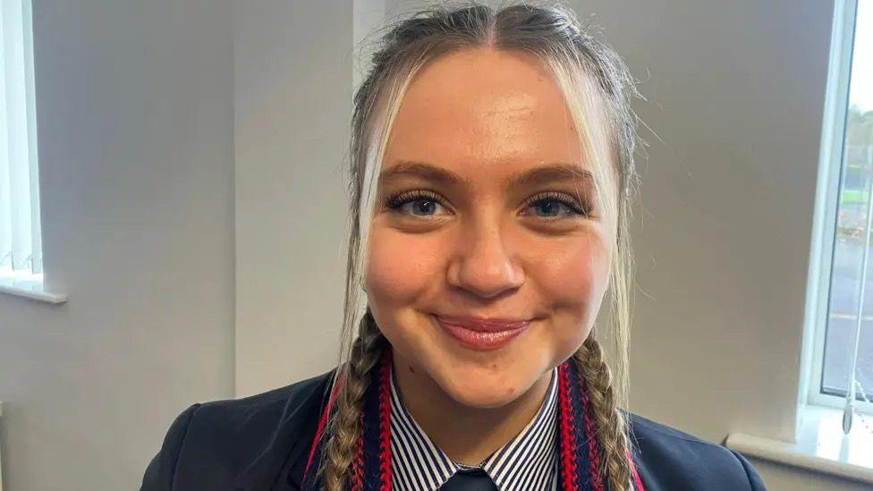 A girl looking at the camera smiling.