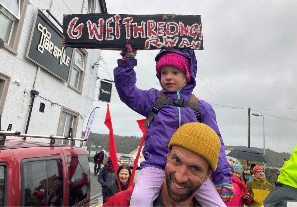 child holding banner on man's shoulders