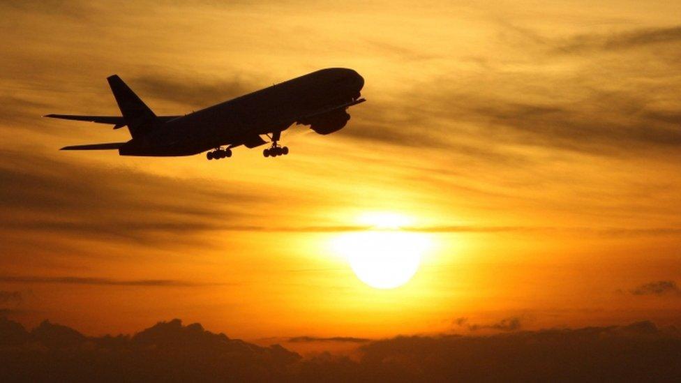 Plane taking off from Heathrow Airport at sunset