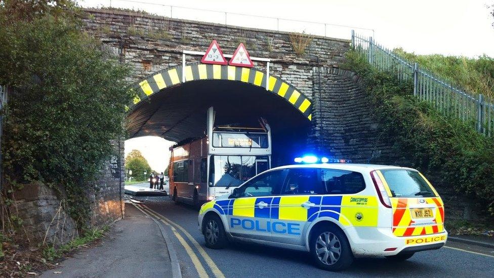 Bus stuck under bridge