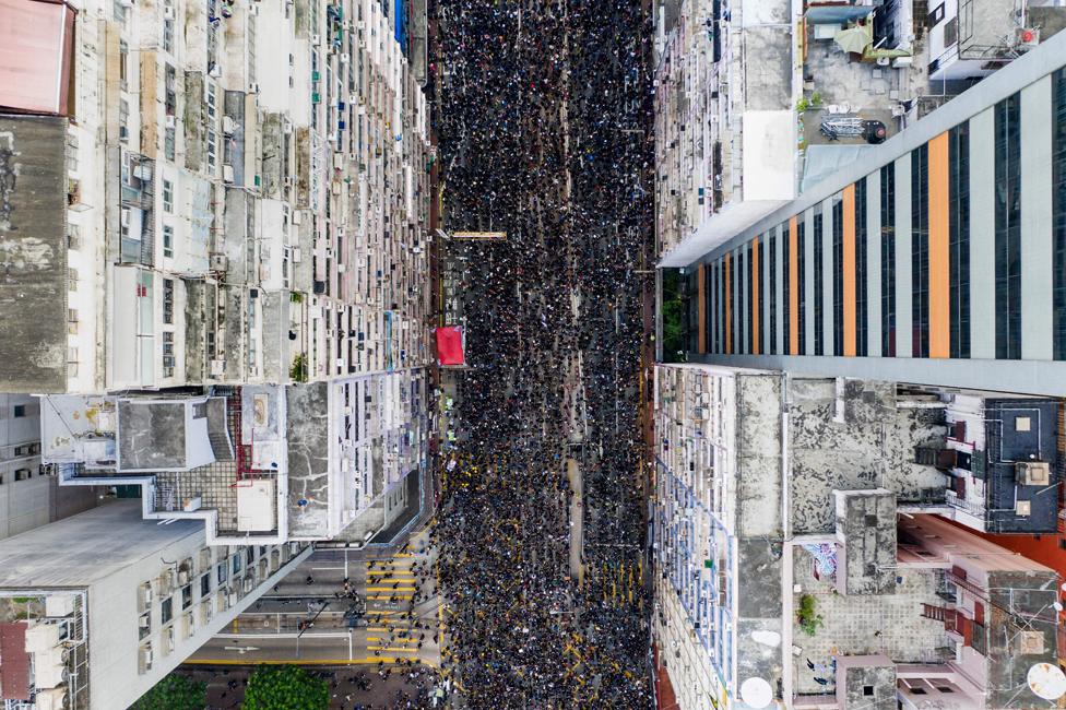 Overhead view shows thousands of protesters marching through the street as they take part in a new rally against a controversial extradition law proposal in Hong Kong on 16 June 2019