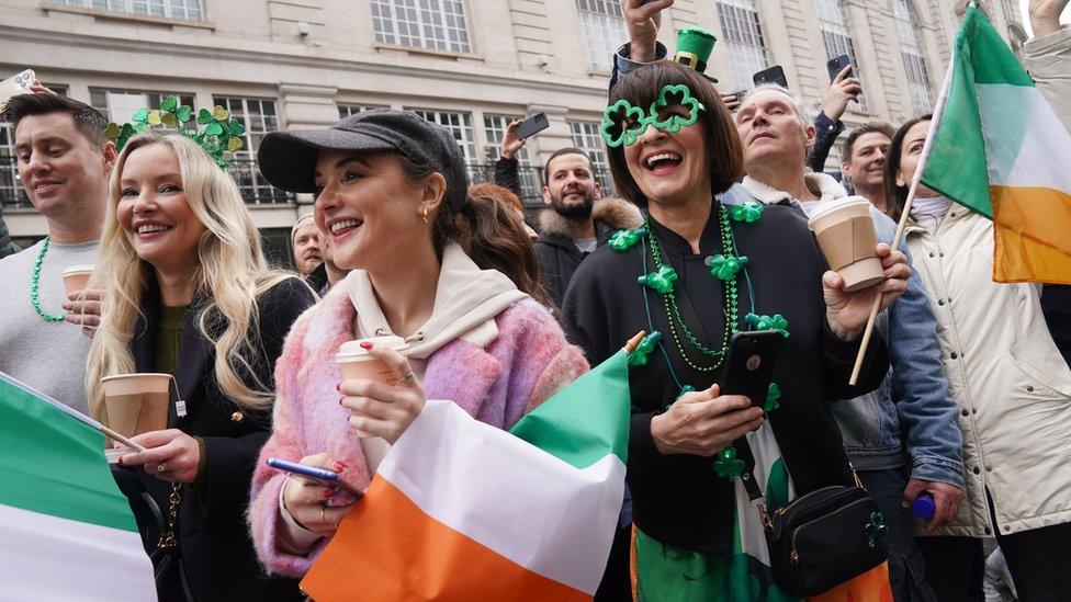 Crowds gathered at the side of a parade route in London.