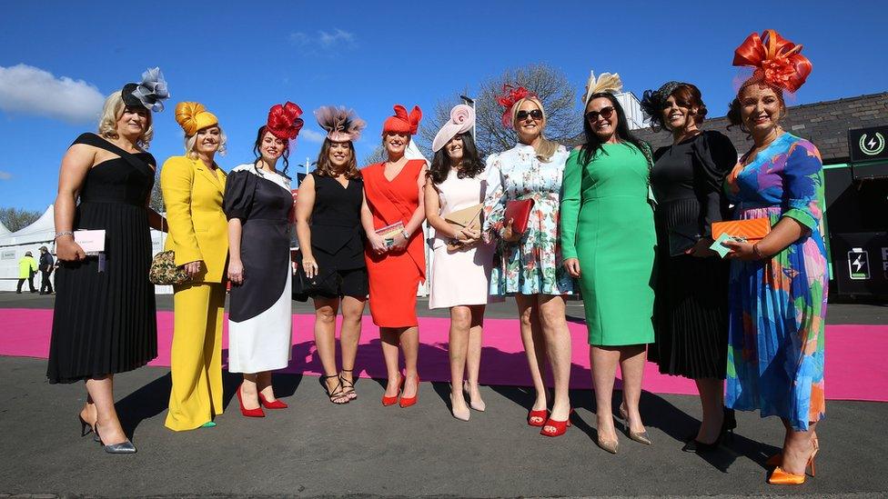 Women pose for photos on Ladies Day at Aintree