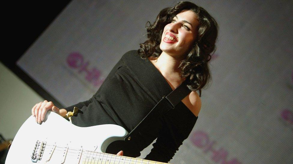 Amy Winehouse poses for photos outside HMV Oxford Street in 2004