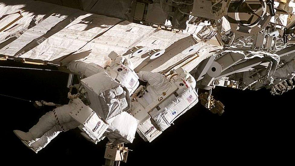 Astronauts Daniel C. Burbank (right) and Steven G. MacLean, representing the Canadian Space Agency, translate along the side of one of the station's trusses on the International Space Station on September 13, 2006.