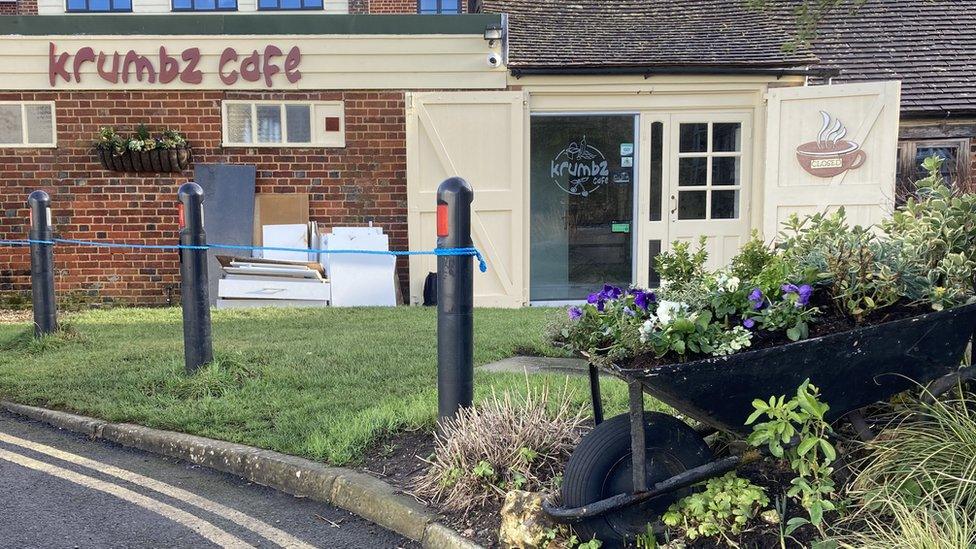 The outside of Krumbz cafe with kitchen units piled up under the cafe sign