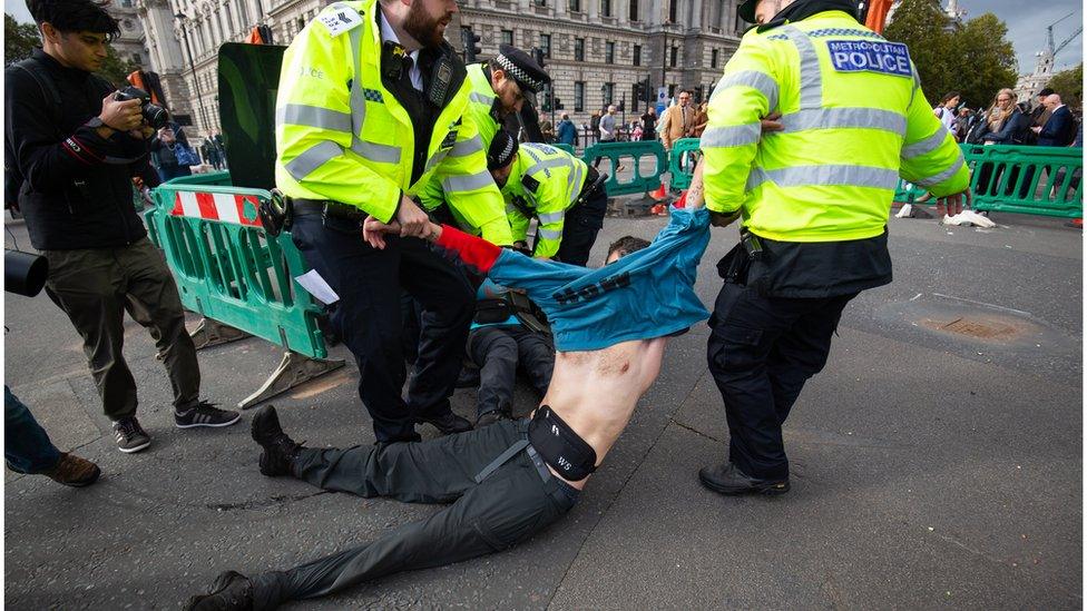 Police officers removing a demonstrator