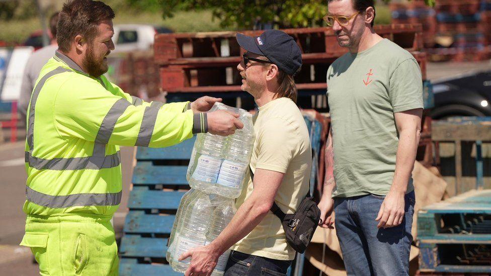 People at bottled water station