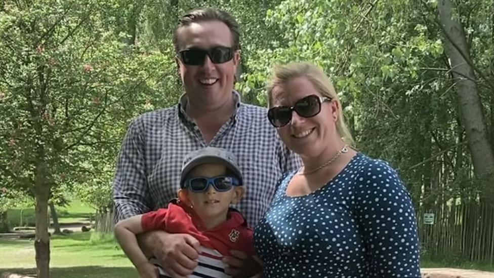 William with father Nigel and mother Alice on a sunny day with trees behind them