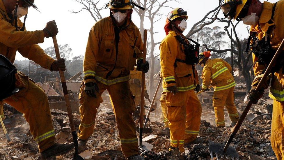 Firefighters dig through a burned out home. Hundreds of people are missing.