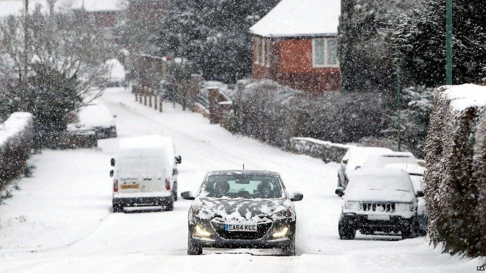 Cars driving down a snowy road