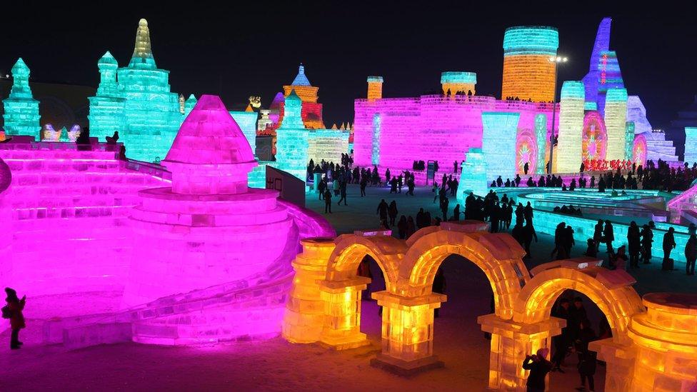 People visit the ice sculptures illuminated by coloured lights at Harbin ice and snow world for the 33rd Harbin International Ice and Snow Festival in Harbin city, China's northern Heilongjiang province, 05 January 2017.