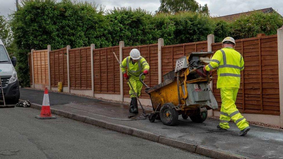 Workers laying asphalt