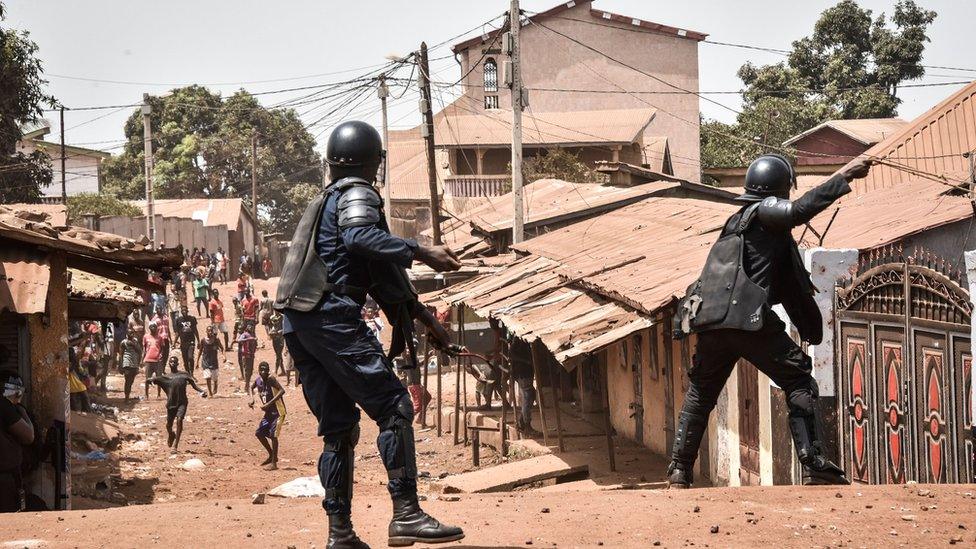 A policemen taking on protesters in a neighbourhood of Conakry, Guinea - 27 February 2020