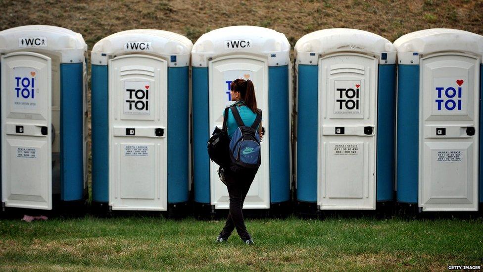 Woman waiting to go the toilet a festival