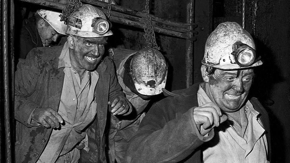 Miners underground coming out of a lift