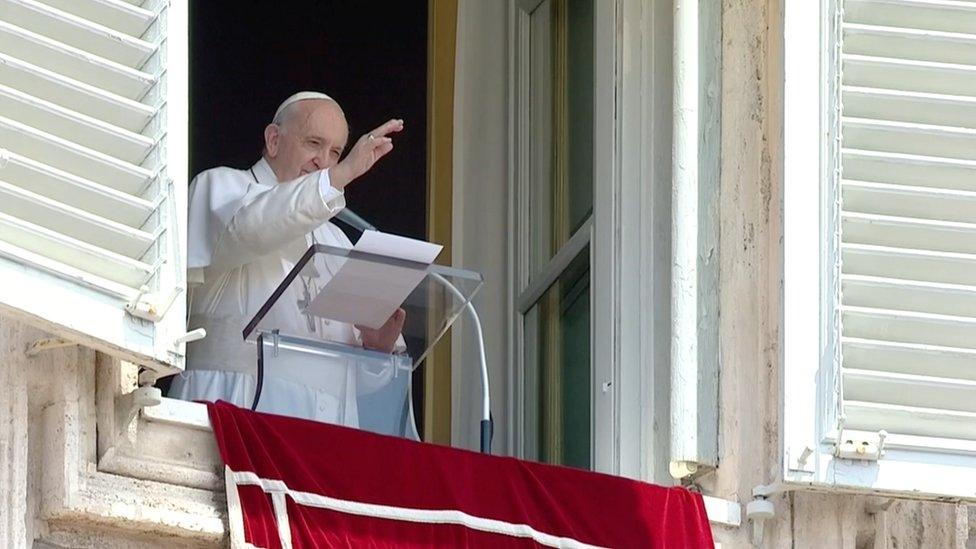 Pope Francis raises his hand in greeting as he delivers the Angelus hours before being admitted to Gemelli hospital