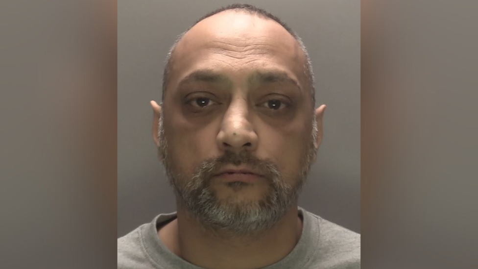 A mugshot of Raj Sidpara, a 50-year-old south-Asian with a short greying beard