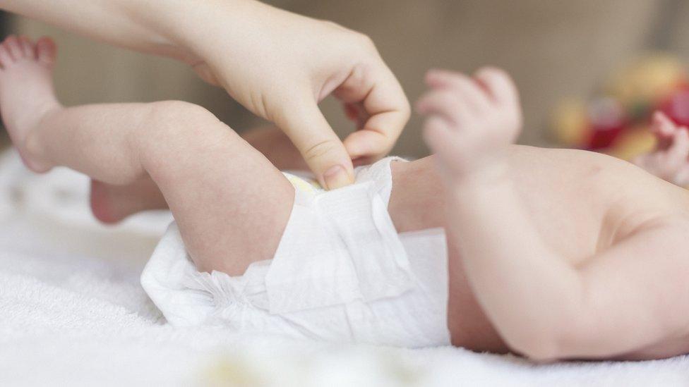 Woman changing baby's nappy